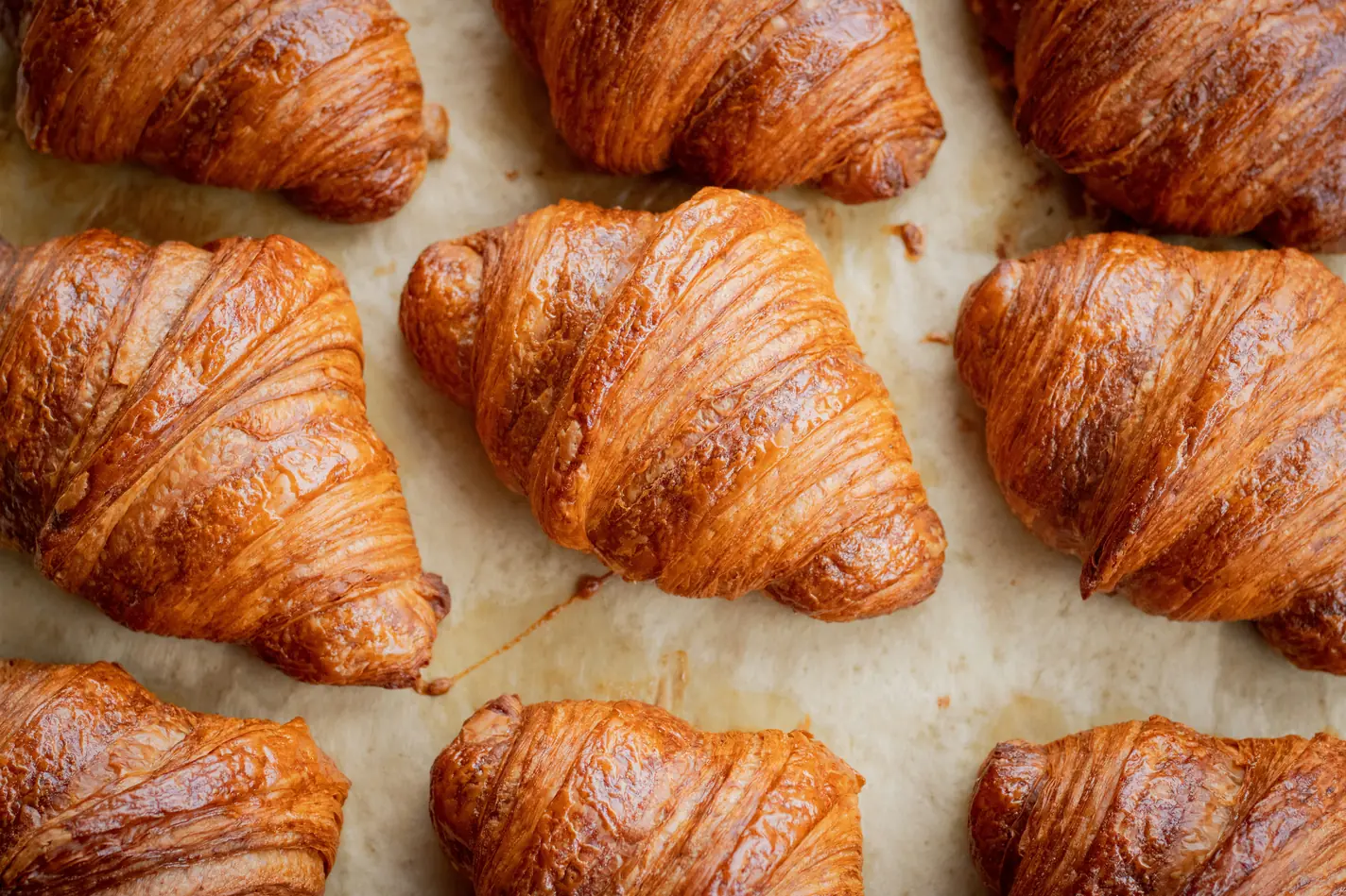 Nybagte croissanter på bagepapir.